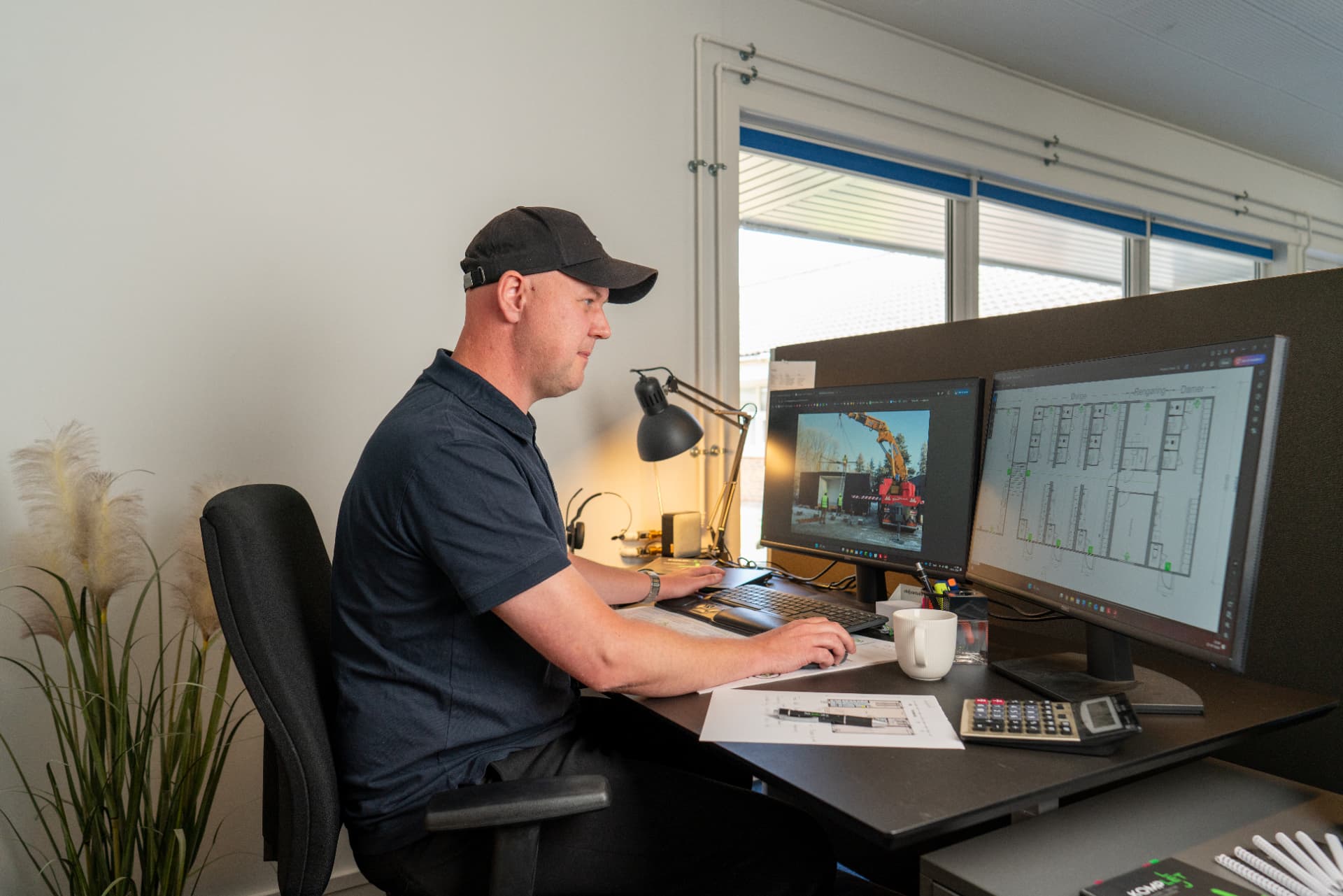 Medarbejder hos Komplet Lej arbejder med tegninger og bestillinger på kontoret